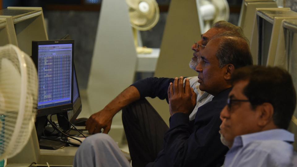 Stockbrokers look at the latest share prices at the Pakistan Stock Exchange in Karachi on February 9, 2023.