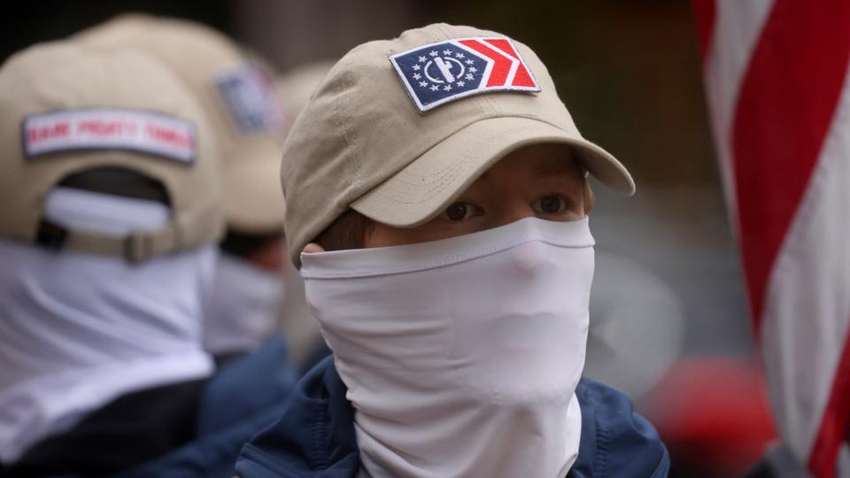 A member of Patriot Front, a white supremacist group, looks on as the group is guarded by members of the Metropolitan Police Department of Washington, DC.