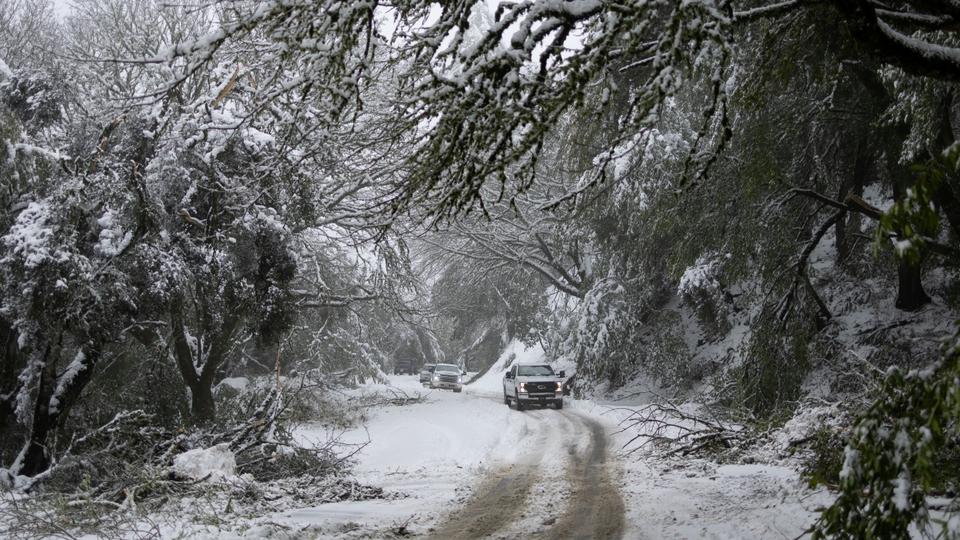 Snow is seen covering hills around the Bay Area as a massive winter storm passes along the west coast, delivering snow, freezing rains, and gusty winds, in Redwood City, California.