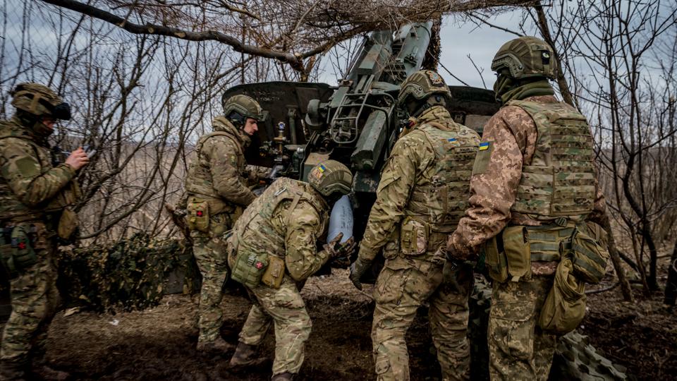 Ukrainian soldiers load a 152 mm shell into a Msta-B howitzer to fire towards Russian positions, near the frontline town of Bakhmut on March 2, 2023.