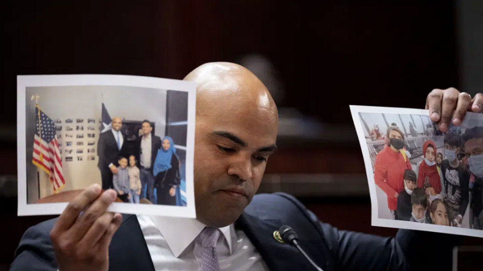 Representative Colin Allred, D-Texas, holds up photographs of a man evacuated out of Afghanistan as he speaks during a hearing on US withdrawal from Afghanistan.