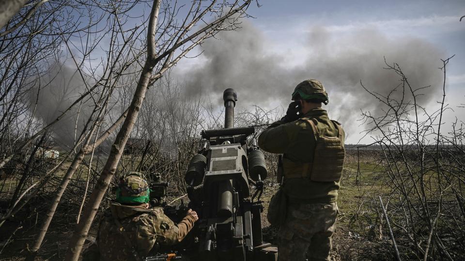 Ukrainian servicemen fire with an M119 105mm howitzer at Russian positions near Bakhmut