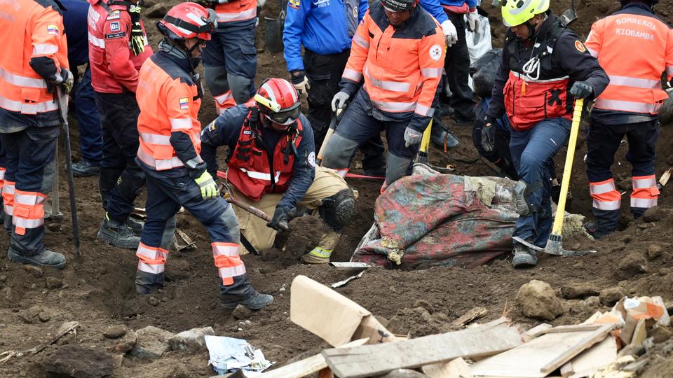 Rescue teams search for survivors at a neighbourhood affected by a landslide in the small city of Alausi.