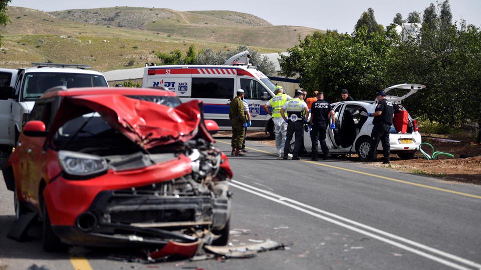 Israeli medics and policemen check a damaged car at the scene of a shooting attack, in the Jordan Valley in the Israeli-occupied West Bank.