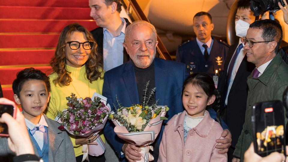 In this photo released by Xinhua News Agency, Brazilian President Luiz Inacio Lula da Silva, centre, and first lady Rosangela Silva, second left, receive flowers presented by children from the Shanghai Children's Palace of the China Welfare Institute upon arrival in Shanghai.