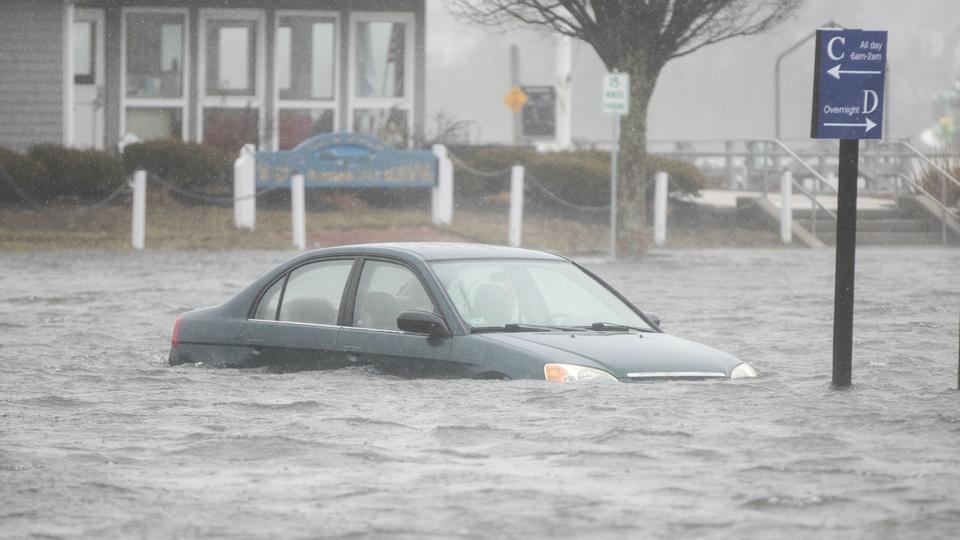 A flooded car parked in a lot behind Front St. as a large coastal storm affects the area on March 2, 2018, in Scituate, Massachusetts. A nor'easter is set to slam the East Coast on Friday, bringing coastal flooding, heavy snow and strong winds to the area.