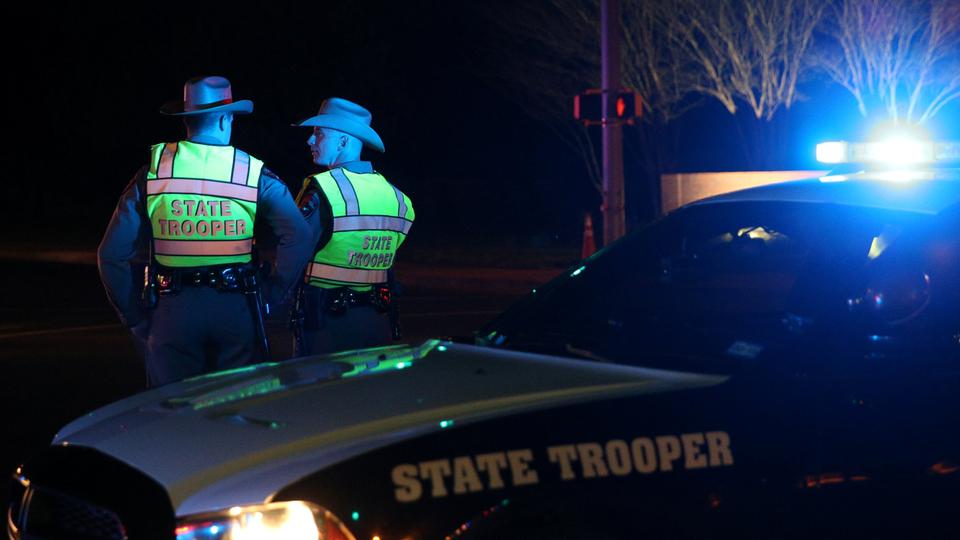 Texas state troopers keep watch at a checkpoint as nearby law enforcement personnel investigate an incident that they said involved an incendiary device in the 9800 block of Brodie Lane in Austin, Texas, US, March 20, 2018.