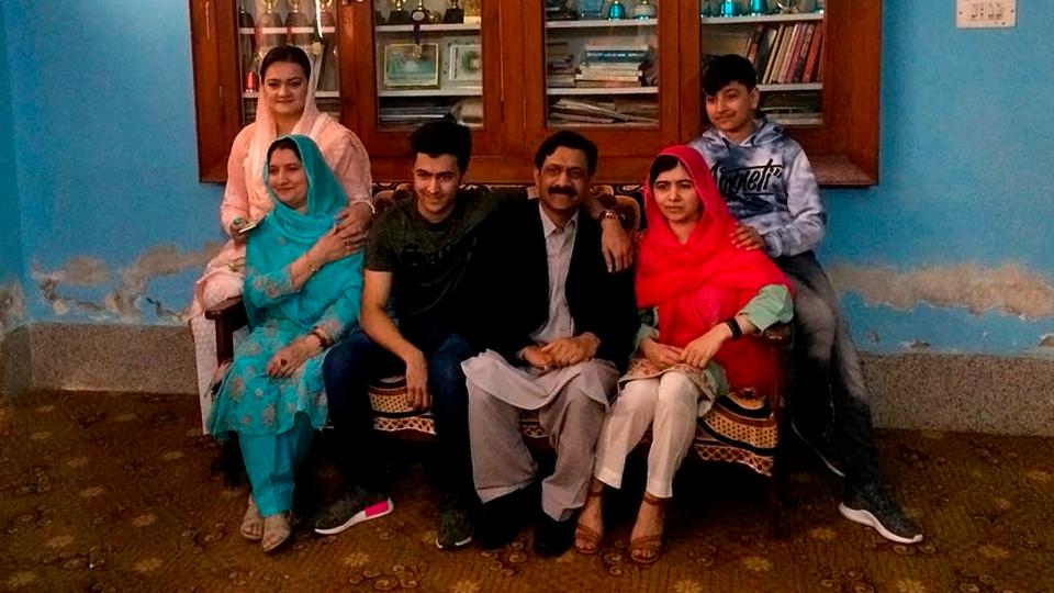 Pakistan's Nobel Peace Prize winner Malala Yousafzai, second right, poses for photograph with her family members and Pakistan Information Minister Marriyum Aurangzeb, left, at her native home during a visit to Mingora, the main town of Pakistan Swat Valley, March 31, 2018.