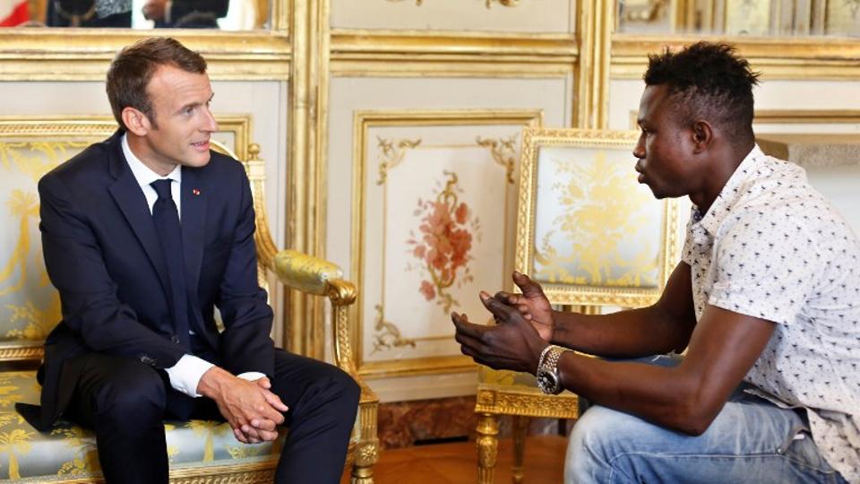 French President Emmanuel Macron (L) speaks with Mamoudou Gassama, 22, from Mali, at the presidential Elysee Palace in Paris, on May, 28, 2018.