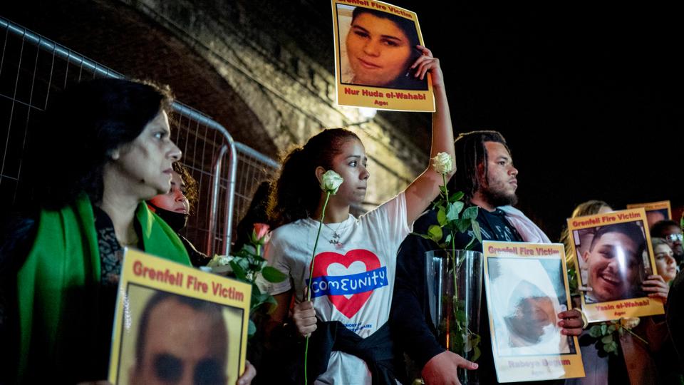 Families and friends who lost loved ones in the Grenfell Tower fire hold portraits of victims as they march in west London at 2300 GMT (midnight local time) on June 14, 2018 to honour the 72 people who died in a fire.
