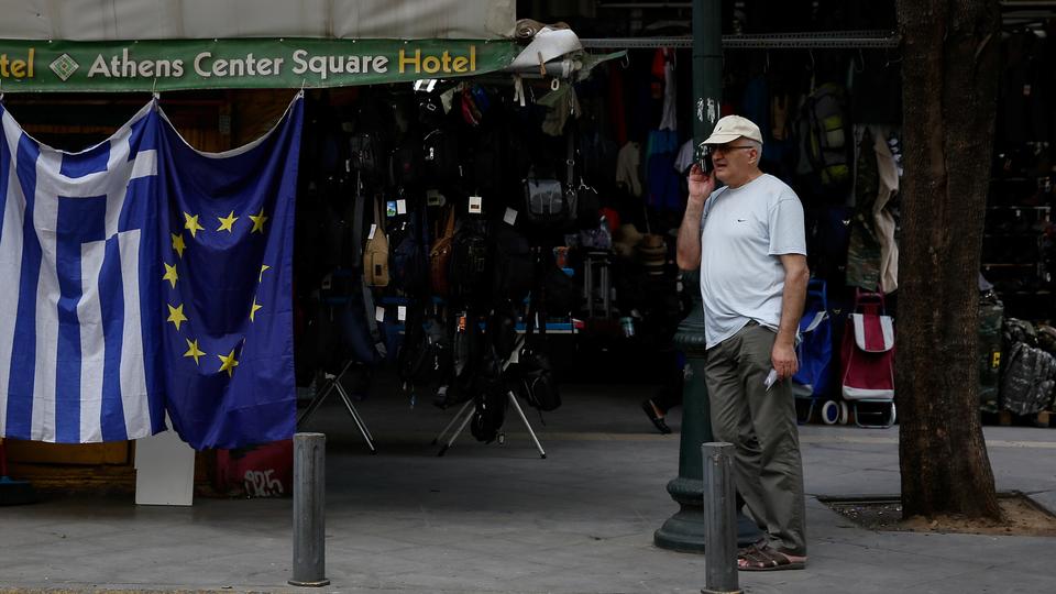 A man stands next to a kiosk selling Greek and EU flags in Athens, Greece, June 21, 2018.