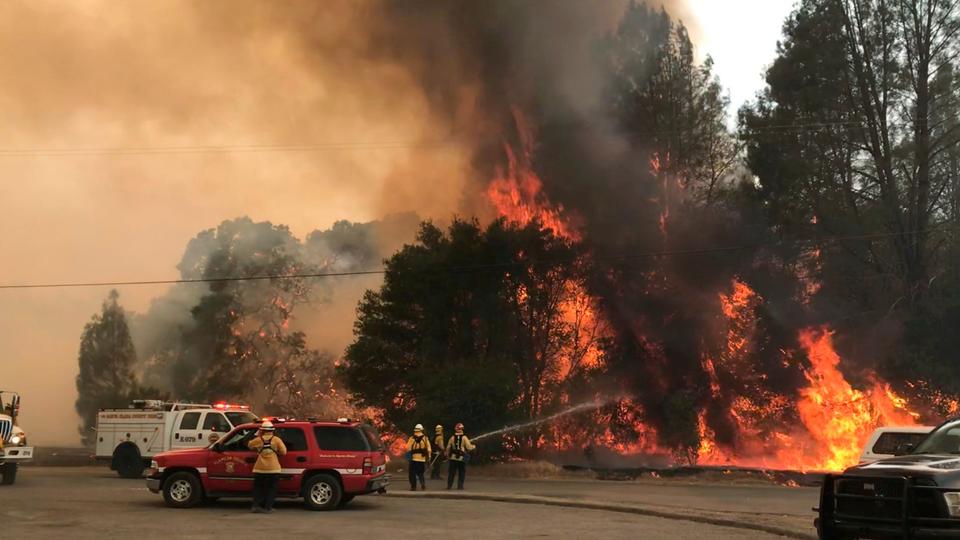 In this photo provided by the Cal Fire Communications, firefighters battle a wildfire in an area northeast of Clearlake Oaks, California, June 24, 2018