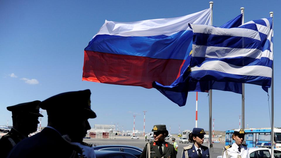 Greek police and army officers stand by Greek, Russian and EU flags as they wait for the arrival of Russian President Vladimir Putin in Athens, Greece airport, May 27, 2016.