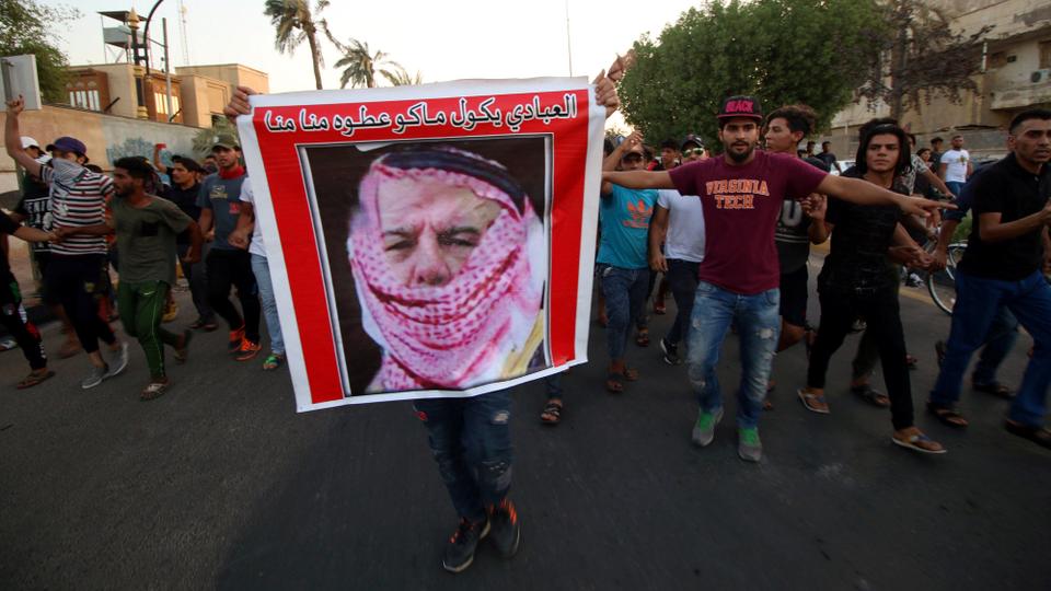 Iraqi protesters shout slogans near the main provincial government building in Basra, Iraq on July 14, 2018.