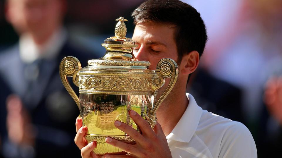 Serbia's Novak Djokovic celebrates with the trophy after winning the men's singles final against South Africa's Kevin Anderson.