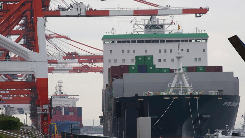 A container ship, right, arrives at a container terminal in Tokyo, Monday, June 18, 2018.