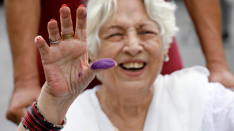 A voter displays her inked thumb after casting her vote during the general elections in Karachi, Pakistan. July 25, 2018.
