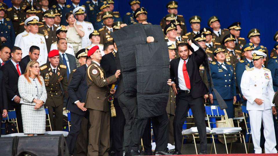 In this photo released by China's Xinhua News Agency, security personnel surround Venezuela's President Nicolas Maduro during an incident as he was giving a speech in Caracas, Venezuela.