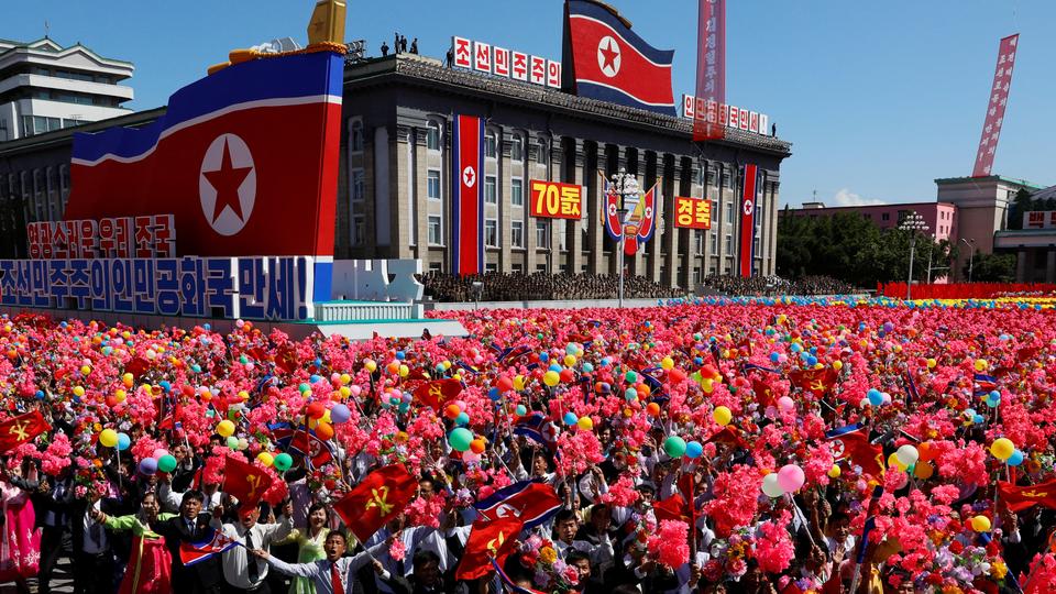 People wave plastic flowers and balloons during a military parade marking the 70th anniversary of North Korea's foundation in Pyongyang, North Korea, September 9, 2018.