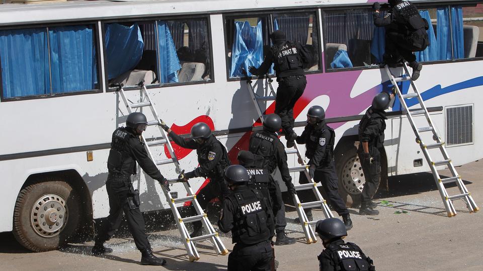 SWAT members of the Beijing Municipal Public Security Bureau storm a hijacked bus during a joint anti-terrorism and riot control drill with a special unit of China's paramilitary police force at a training ground on the outskirts of Beijing Thursday, September 23, 2010.