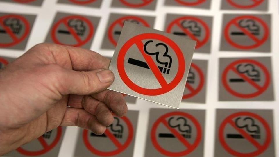 A printer lays a no smoking sign alongside others at First Safety Signs in Bishops Stortford in eastern England, June 29, 2007.