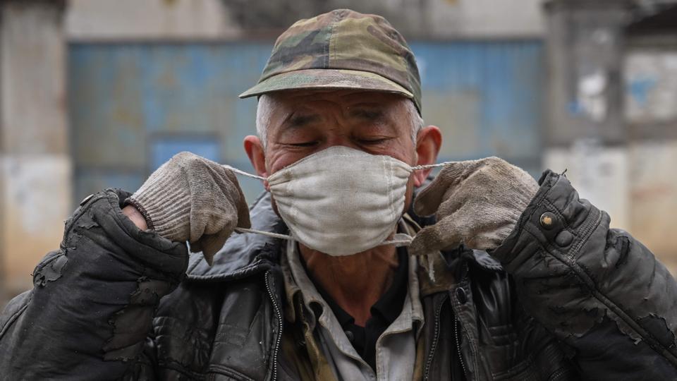 A man puts a protective mask in a neighborhood on the outskirts of Wuhan in China’s central Hubei province on January 27, 2020, amid a deadly virus outbreak which began in the city.