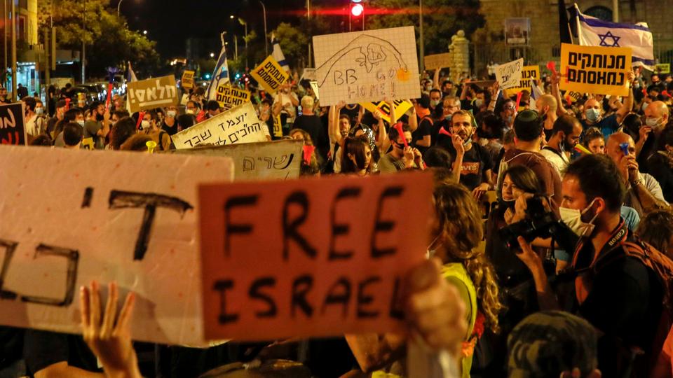 Israeli demonstrators lift placards during a rally against Benjamin Netanyahu outside the prime minister's residence in Jerusalem, on July 18, 2020.
