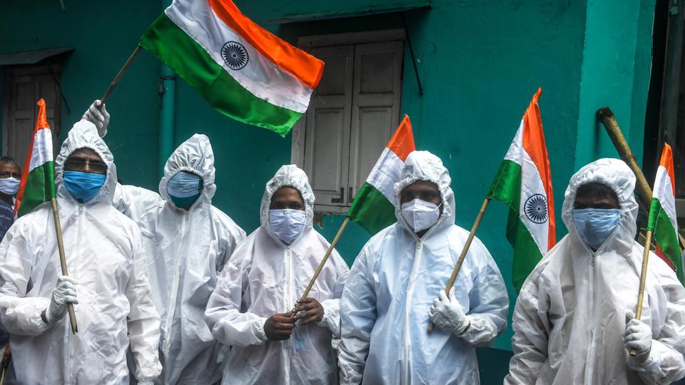 Frontline Covid-19 coronavirus health workers, patients ambulance drivers, crematorium workers hold Indian national flags as part of the Independence Day celebrations in Kolkata on August 15, 2020.