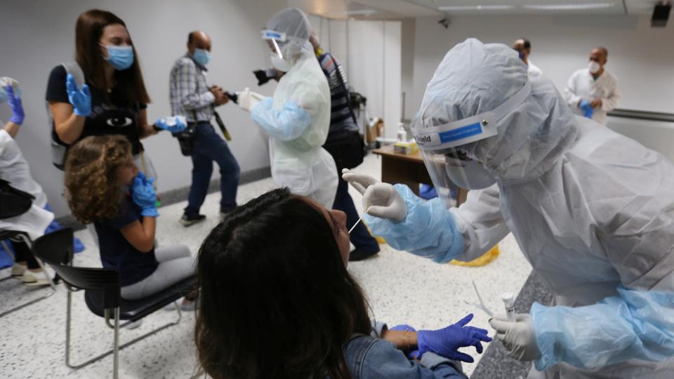 Health workers take swab samples from passengers who arrived at Beirut International Airport on its re-opening day following the coronavirus disease outbreak on July 1, 2020.