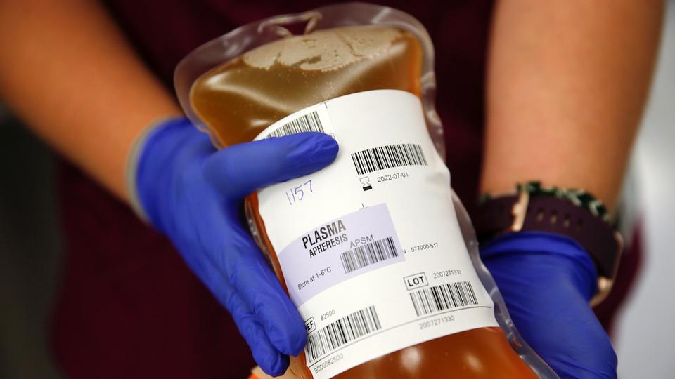 A blood collection specialist holds a bag of convalescent plasma from a recovered coronavirus patient at the Central Seattle Donor Center of Bloodworks Northwest, in Seattle, Washington, US September 2, 2020.