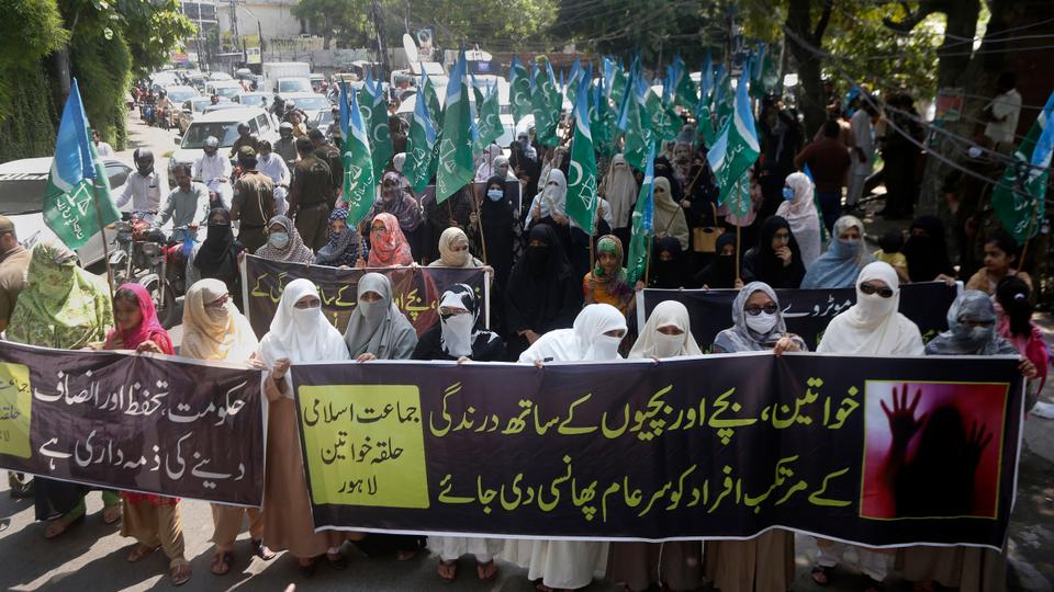 Supporters of the religious group 'Jamaat-e-Islami, carry a banner reading 