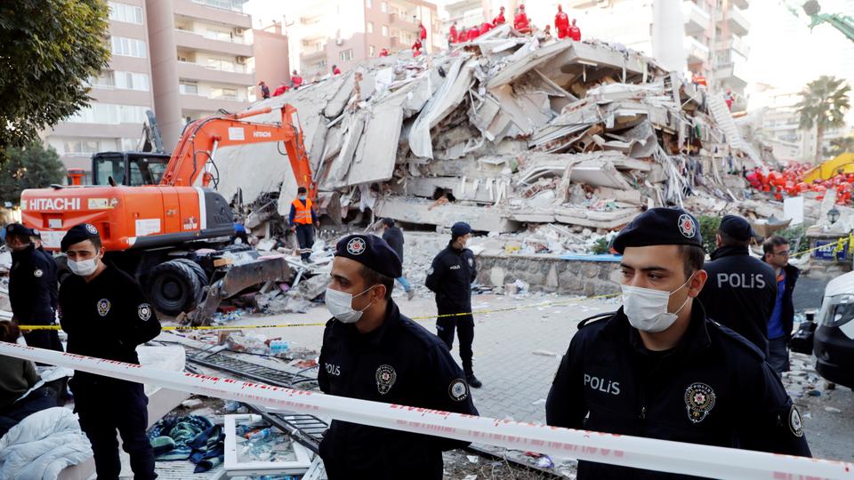 Police officers stand next to debris during rescue operations after an earthquake struck the Aegean Sea, in the coastal province of Izmir, Turkey, on October 31, 2020.