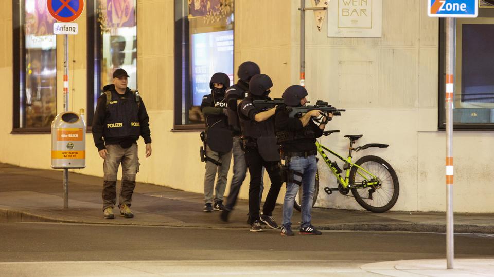 Police officers aim their weapons on the corner of a street after exchanges of gunfire in Vienna, Austria on November 2, 2020.