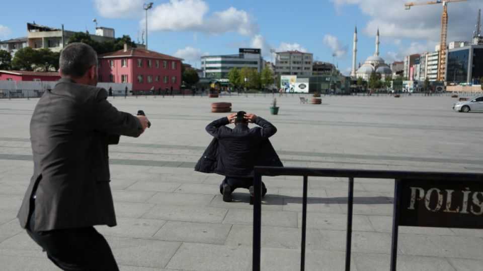 A plain clothes police officer points his gun at an assailant who attempted to shoot prominent Turkish journalist Can Dundar, outside a courthouse in Istanbul, Turkey on May 6, 2016. 