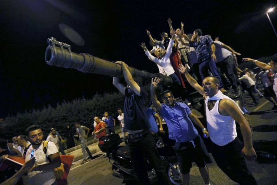 People stand on a Turkish army tank at Ataturk airport in Istanbul, Turkey July 16, 2016.