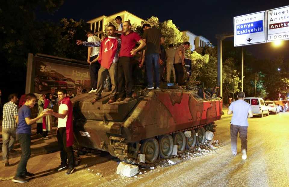 Supporters of Turkish President Tayyip Erdogan stand on an abandoned tank during a demonstration outside parliament building in Ankara, Turkey, July 16, 2016.