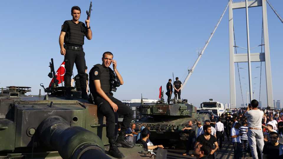 Policemen stand atop military armored vehicles after a defeated coup attempt on the Bosphorus Bridge in Istanbul, Turkey, on July 16, 2016.