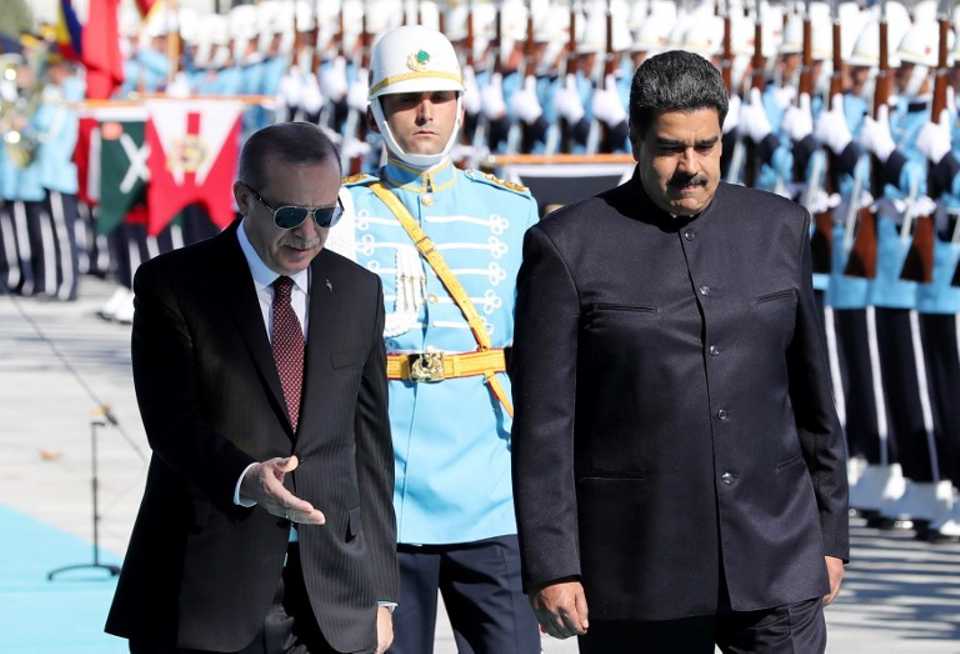 Venezuelan President Nicolas Maduro (R) and Turkish President Recep Tayyip Erdogan walk past honor guard during an official welcome ceremony, at the Presidential Complex in Ankara, on October 6, 201