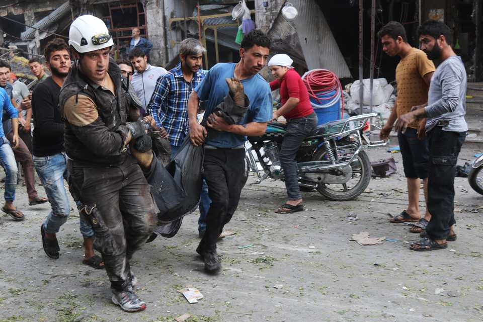 Syrian residents and members of the Syrian Civil Defence, also known as White Helmets, carry a victim following a reported air strike on a vegetable market in Maaret al Numan in Syria's northern province of Idlib on October 8, 2017.