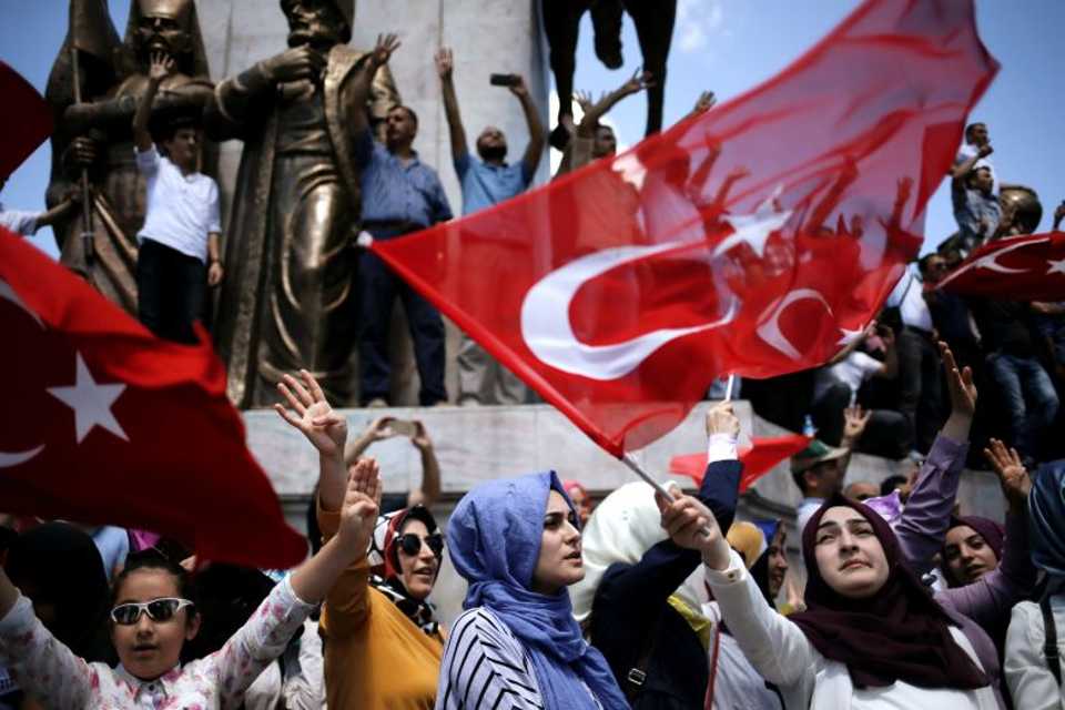 Supporters of Turkish President Tayyip Erdogan shout slogans and wave Turkish national flags during a demonstration in Sarachane park in Istanbul, Turkey, July 19, 2016.
