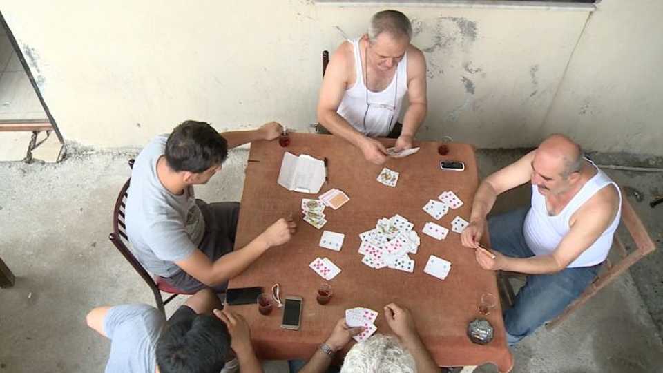 The picture shows four people playing a game of '51 cards'.