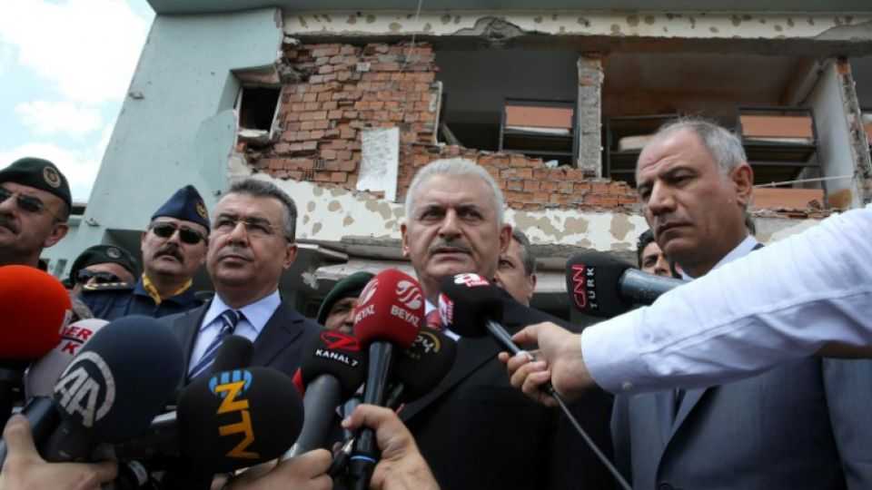 Turkish Prime Minister Binali Yildirim (C) speaks to the media during his visit at the Police Special Operation Department's Headquarters in Golbasi district in Ankara which was badly damaged during the attempted coup.