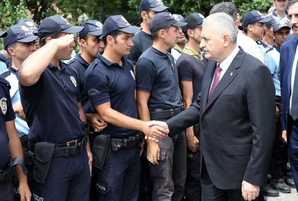 Turkish Prime Minister Binali Yildirim (L) meets with Turkish police officers as he visites the Police Special Operation Department's Headquarters in Golbasi district in Ankara.