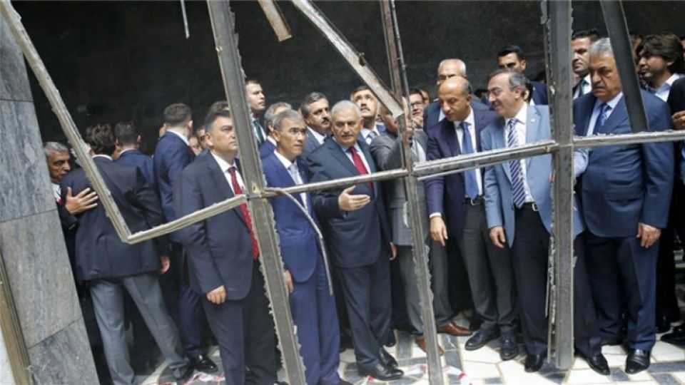 Turkey's Prime Minister Binali Yildirim (C) visits a section of Turkey's parliament which was hit by an air strike during the failed coup.