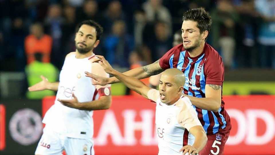 Selcuk Inan and Sofiane Feghouili of Galatasaray in action against Okay Yokuslu of Trabzonspor during a Turkish Super Lig match between Trabzonspor and Galatasaray at Medical Park Stadium in Trabzon, on Sunday.