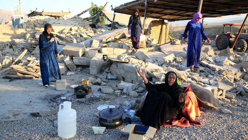 Women sit near debris of a building in Kalaleh town of Kermanshah, Iran on November 14, 2017 following the magnitude 7.3 earthquake that hit Iraq and Iran.