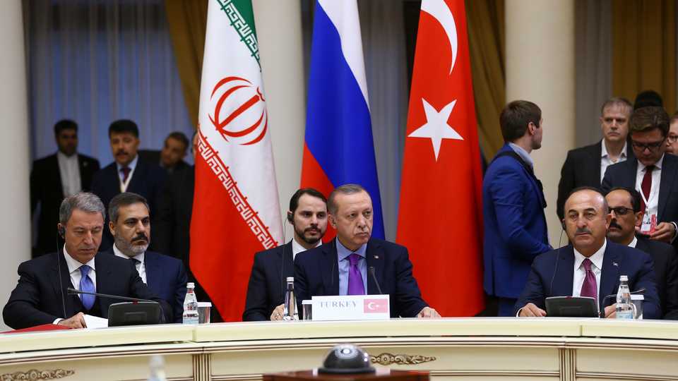 Turkey's President Recep Tayyip Erdogan, center, flanked by Foreign Minister Mevlut Cavusoglu, right, and Chief of Staff Gen. Hulusi Akar, left, sit during a meeting with Russia's President Vladimir Putin and Iran's President Hassan Rouhani, in Sochi, Russia, Wednesday.