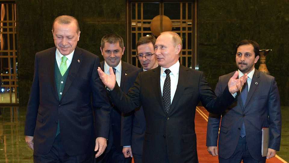 Turkish President Recep Tayyip Erdogan (L) welcomes Russian President Vladimir Putin (C) to Ankara on December 11, 2017.