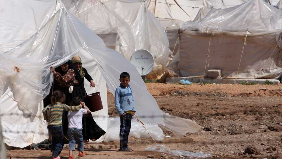 This file photo taken on March 21, 2012 shows Syrian refugee children standing in front of their tent at a refugee camp near the Turkish border town of Reyhanli in Hatay province, Turkey.