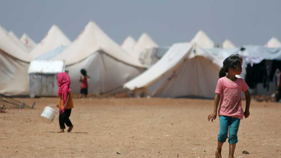 In this June 5, 2017 file photo, displaced Syrian children walk outside their family tents at a camp outside Jarablus, Aleppo province, Syria.